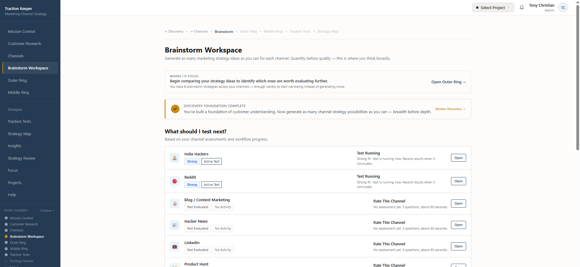 Traction Keeper Brainstorm Workspace showing Discovery Foundation Complete, the What Should I Test Next priority panel with channel assessments, and active tests on Indie Hackers and Reddit